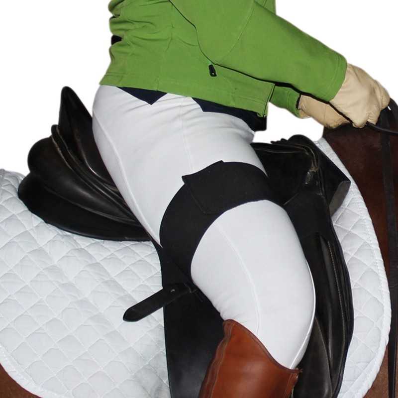 Cavaleiro com casaco verde, luvas bege e calças brancas montando cavalo com sela preta sobre manta branca