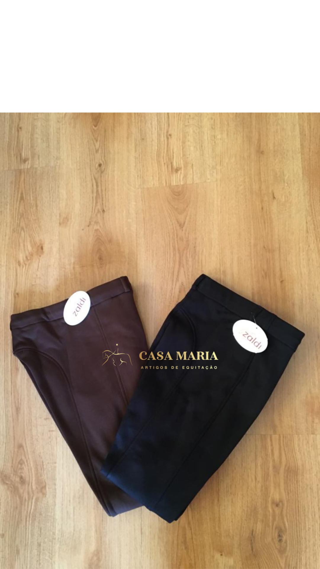 Dois pares de calças de montar em pele preto e castanho com etiquetas Zaldi sobre chão de madeira