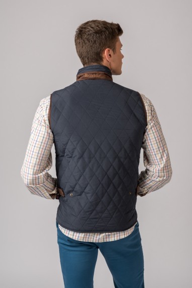 Colete azul escuro matelassê com detalhes castanhos no colarinho visto de trás