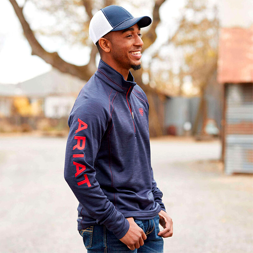 Homem a usar casaco azul escuro com texto ARIAT vermelho na manga