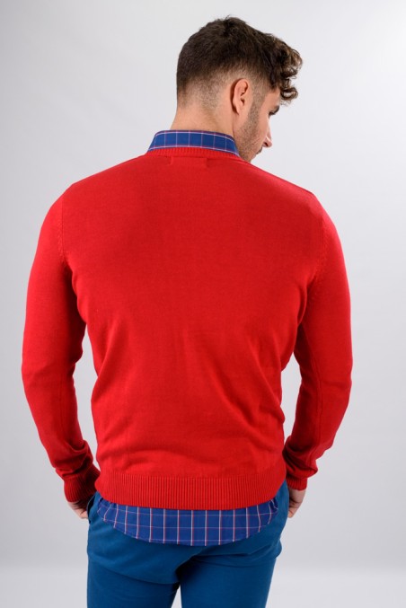 Homem de costas com camisola vermelha, camisa azul quadriculada e calças azuis