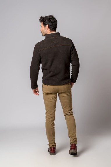 Homem de costas a usar casaco castanho escuro e calças beges