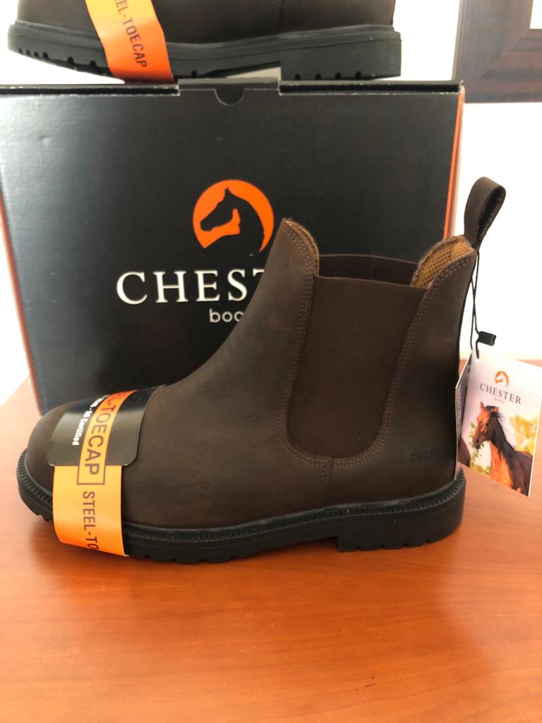 Botas Chester castanhas com biqueira de aço e elástico lateral em superfície de madeira