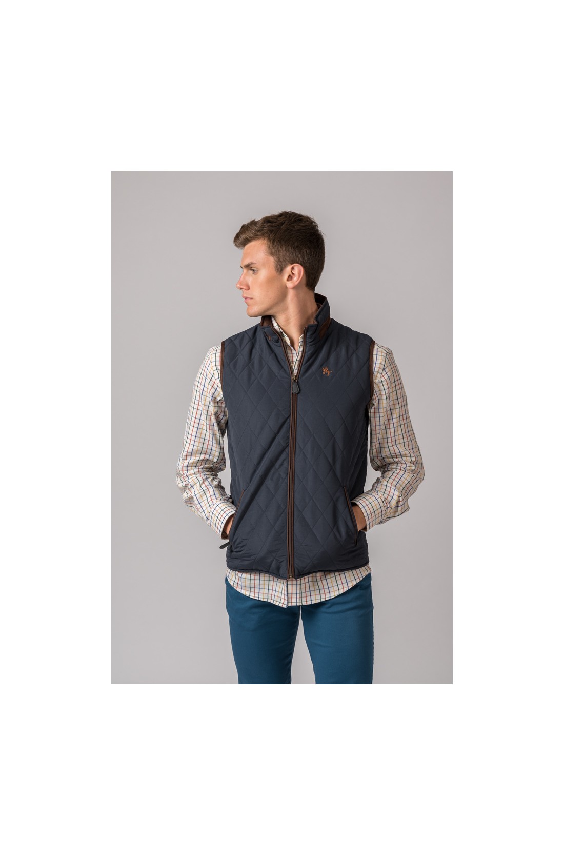 Colete acolchoado azul escuro com padrão losangos e camisa xadrez