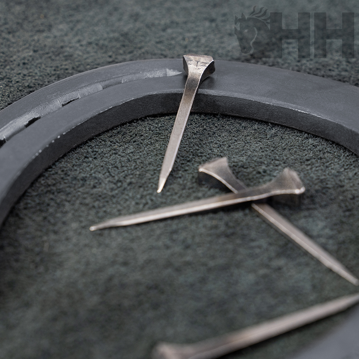 Pregos de metal prateado em superfície cinza com objeto circular