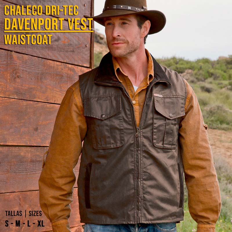 Colete castanho escuro masculino com bolsos e fecho, usado sobre camisa castanha num cenário natural.