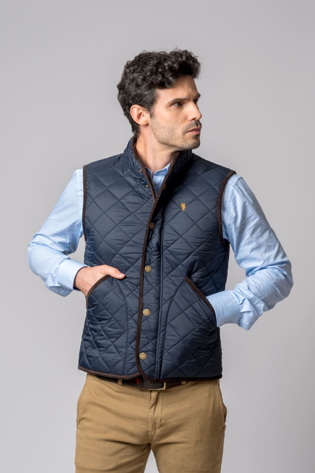 Colete acolchoado azul escuro com botões metálicos usados por homem