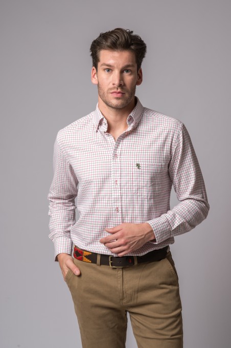 Homem a usar camisa de padrão quadrado e calças castanhas com cinto colorido.