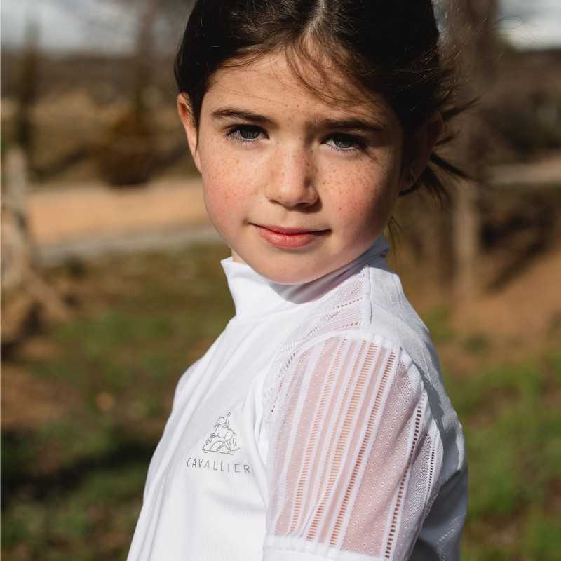 Menina com camisa branca com logo Cavalier e mangas transparentes em ambiente exterior