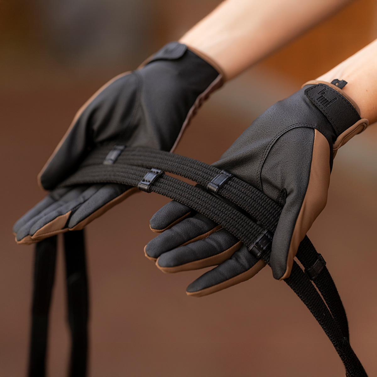 Par de luvas pretas e cinza com tiras elásticas e fecho de velcro no punho