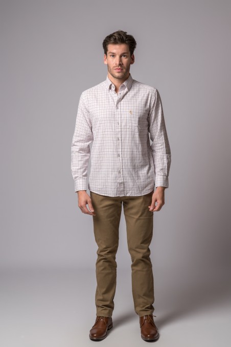 Homem com camisa xadrez branca e calças castanhas, sapatos castanhos, fundo cinza