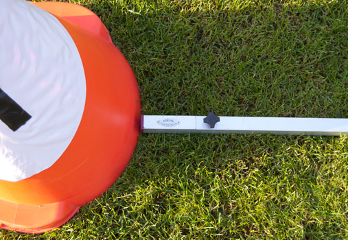 Equipamento laranja e branco com barra branca e relva