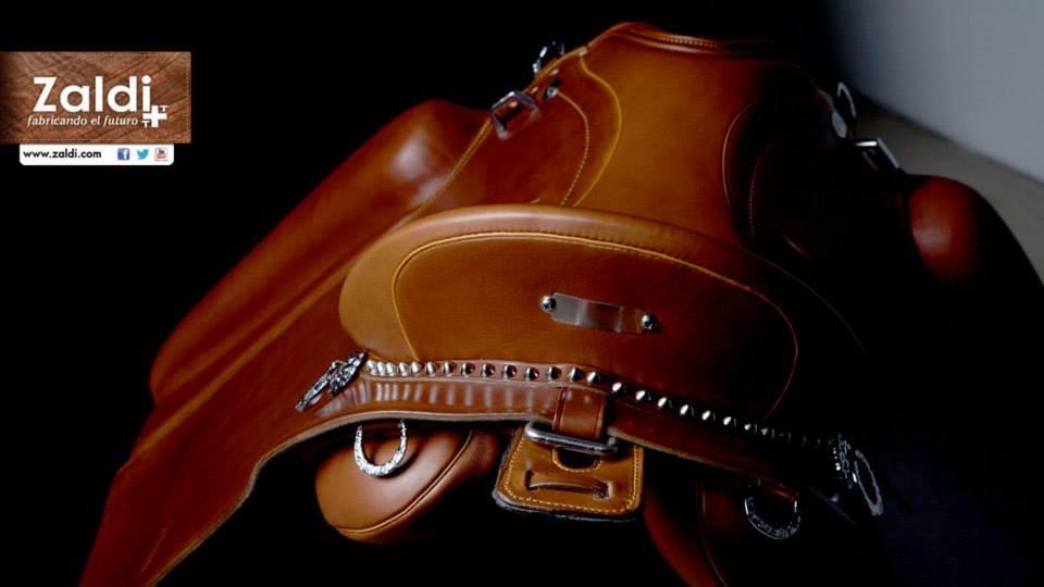 Sela de equitação em couro castanho com detalhes metálicos