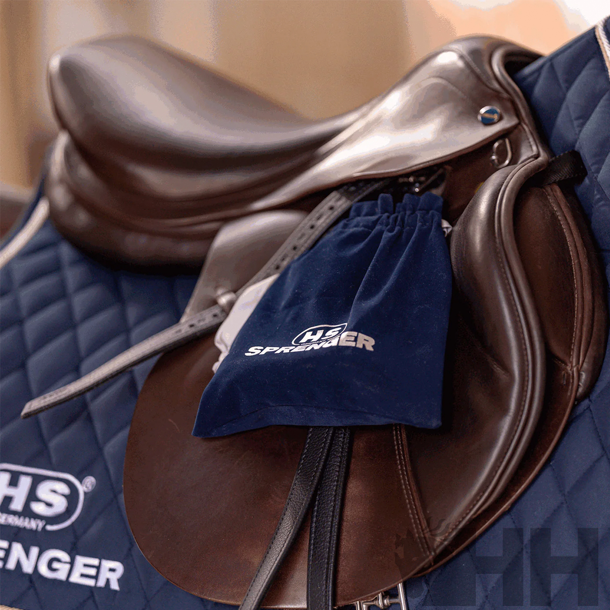 Sela de equitação castanha sobre manta azul acolchoada com saco HS Springer