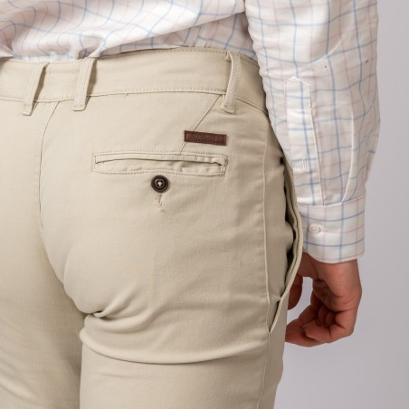 Calças bege com bolso e etiqueta REDWOOD, camisa branca com padrões azuis e cor-de-rosa.