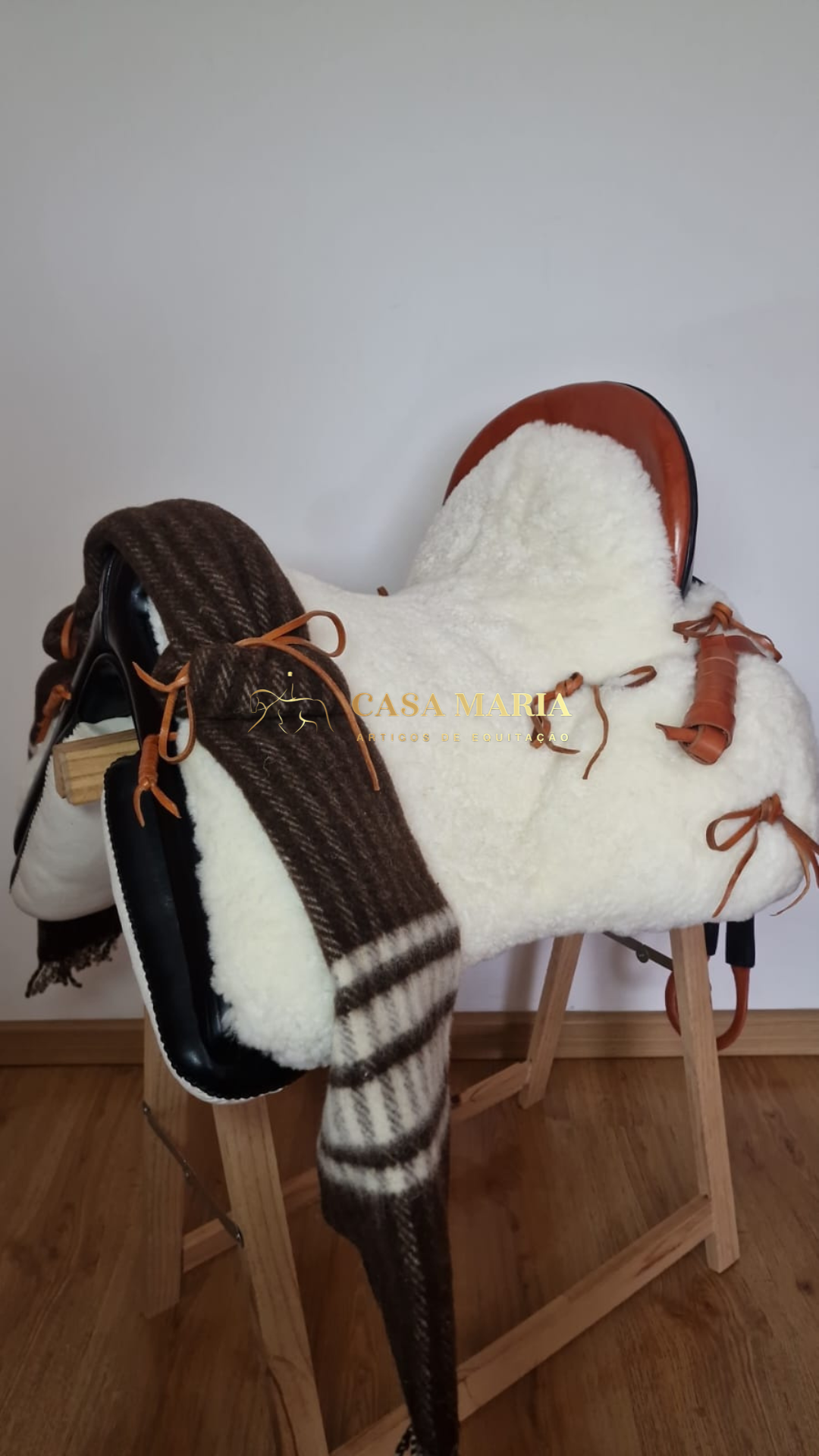 Sela de cavalo com cobertura branca de pelo sintético e manta de lã castanha
