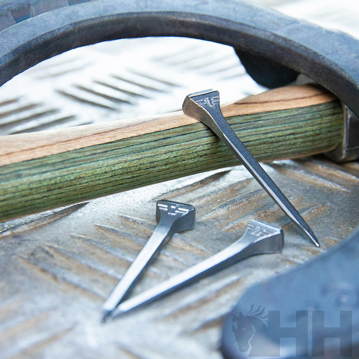 Cravos metálicos e madeira sobre superfície metálica com textura antiderrapante