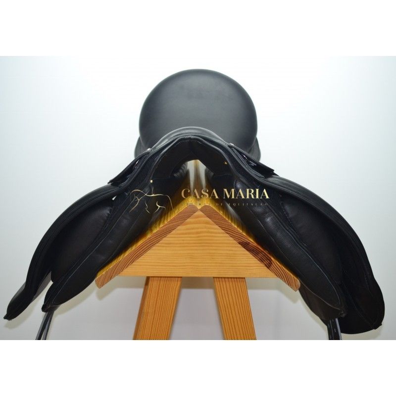 Sela de equitação preta em couro sobre suporte de madeira