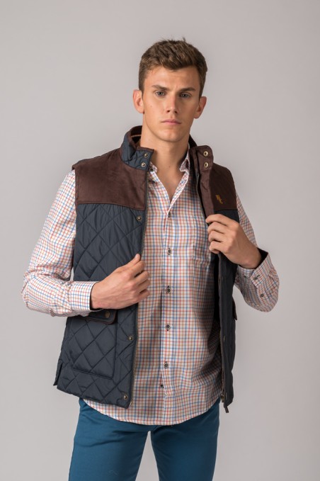 Colete masculino azul escuro acolchoado com detalhe castanho e camisa de botão xadrez