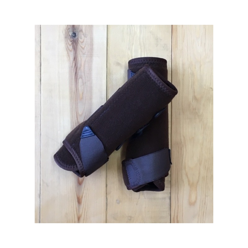 Bandagens marrons para patas de cavalo com ligas cinzentas sobre madeira clara