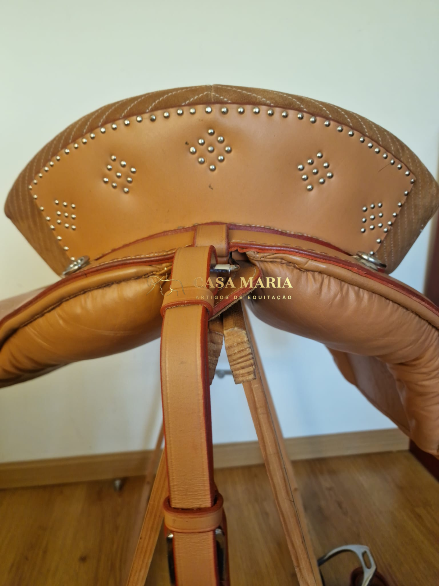 Selim de equitação em couro bege com tachas metálicas e texto CASA MARIA