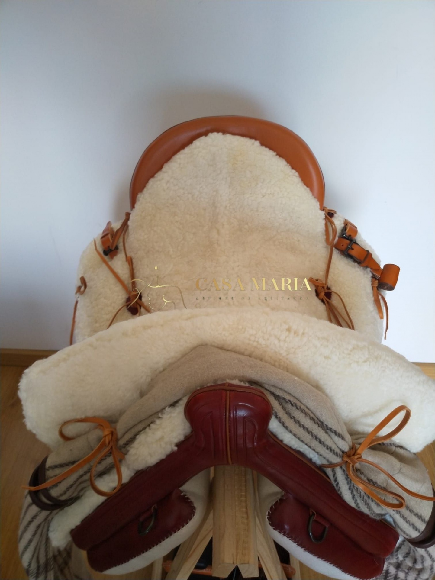 Selim de cavalo com forro em lã branca e couro castanho e vermelho