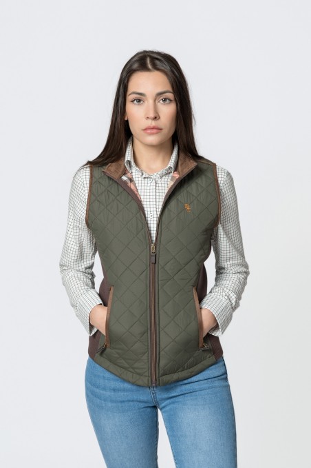 Colete acolchoado verde-oliva com bolsos castanhos, camisa branca quadriculada e jeans azuis