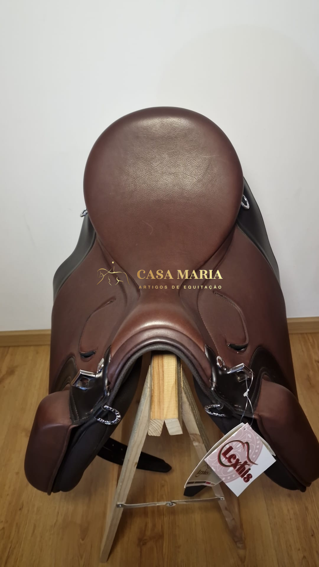 Sela de equitação em couro castanho com etiqueta branca pendurada