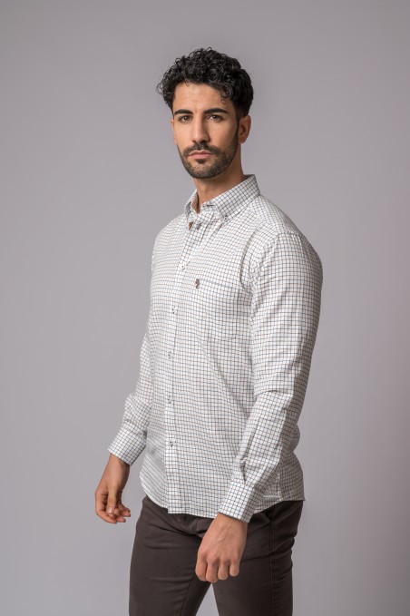 Homem a usar camisa às quadrículas branca e castanha e calças castanhas num fundo cinzento liso