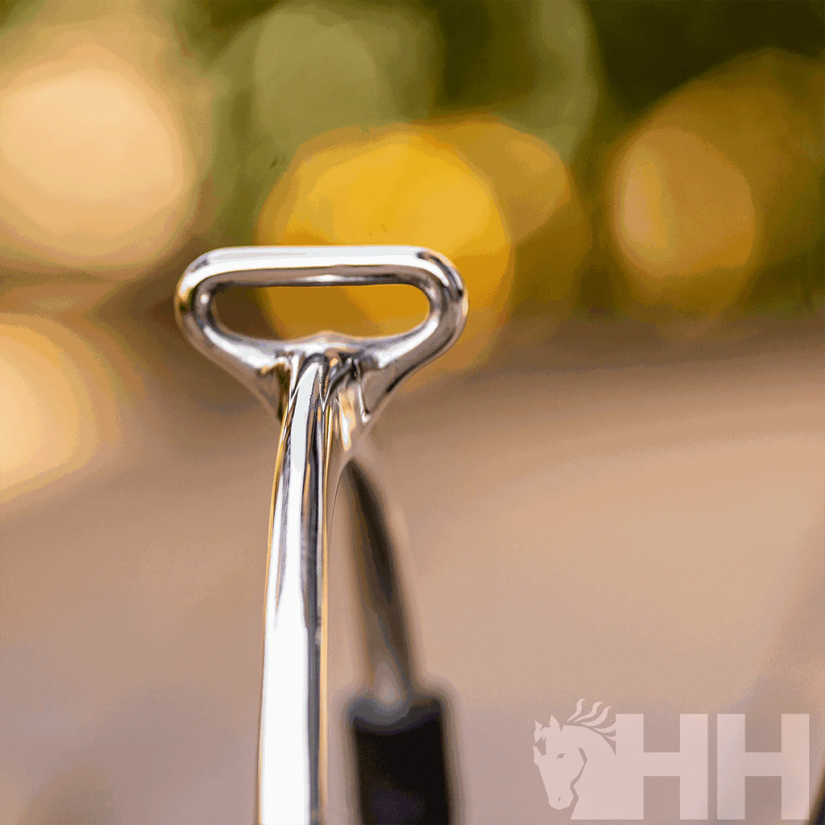 Abridor de garrafas metálico cromado com alça arredondada e fundo desfocado