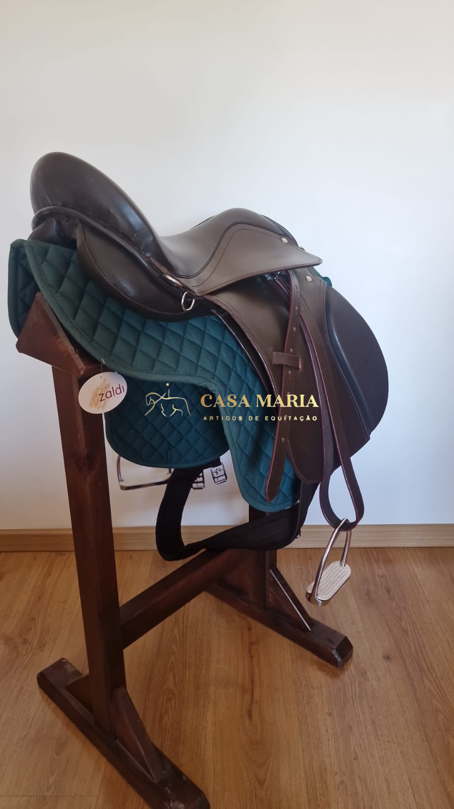 Sela de equitação em suporte de madeira com acolchoado verde-escuro