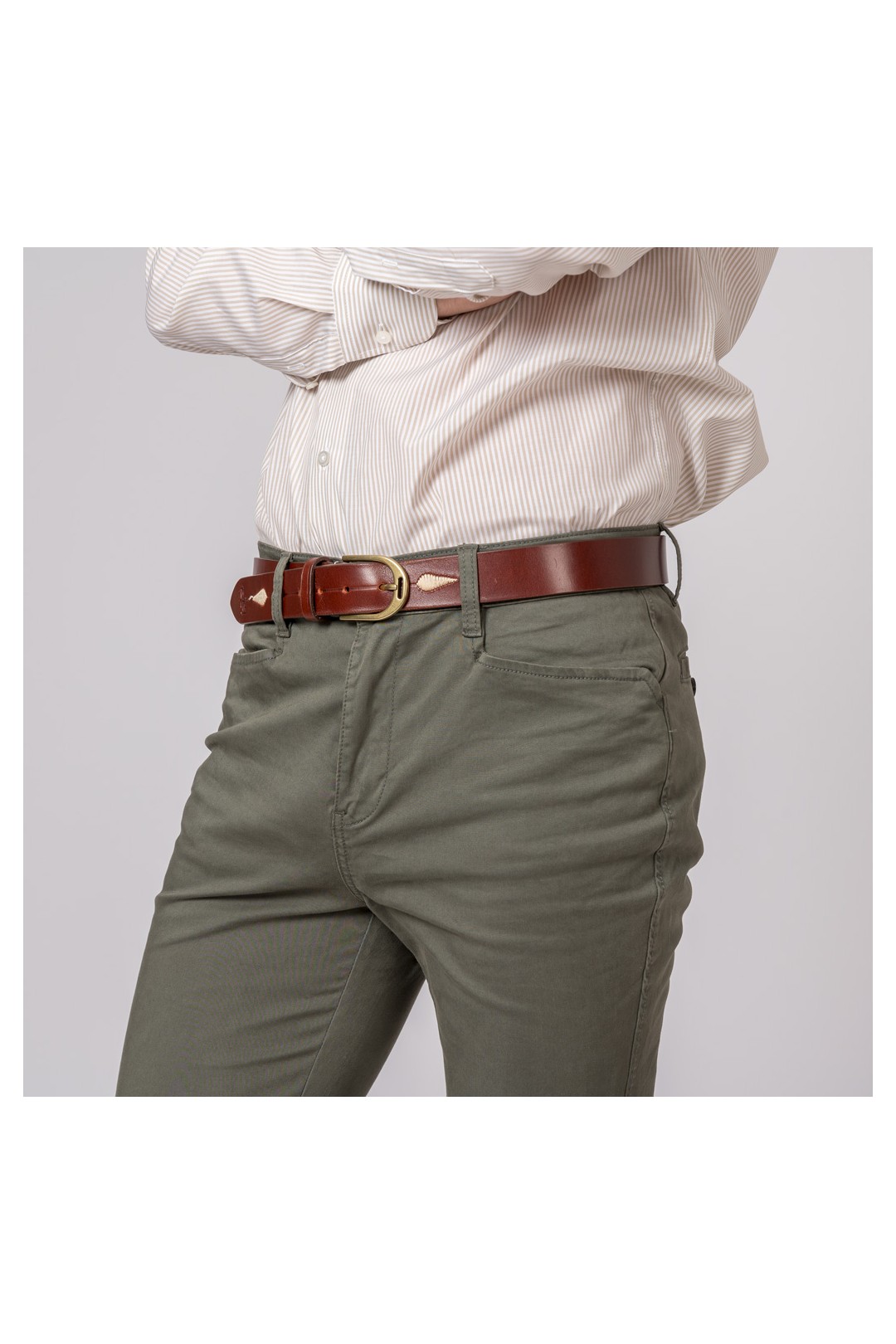 Pessoa com calças verdes, cinto de couro castanho e camisa branca riscada.
