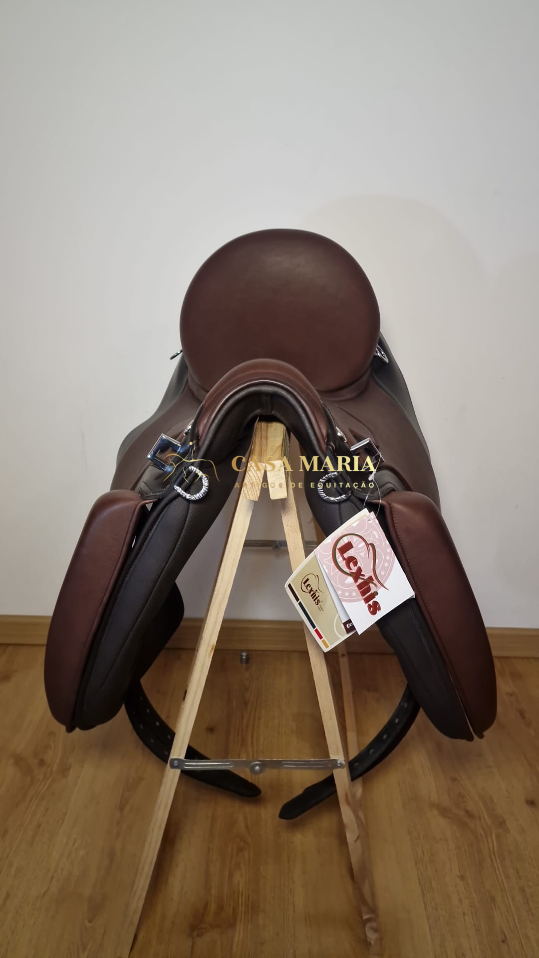 Sela de equitação castanha em couro colocada numa base de madeira