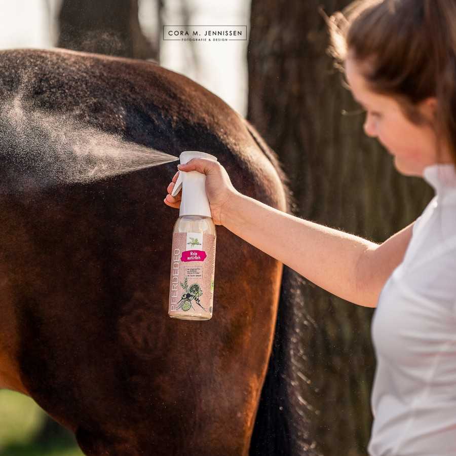 Pessoa a aplicar spray repelente em cavalo castanho com rótulo mostrando mosquito