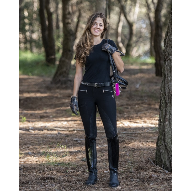 Mulher com roupa de equitação preta numa floresta