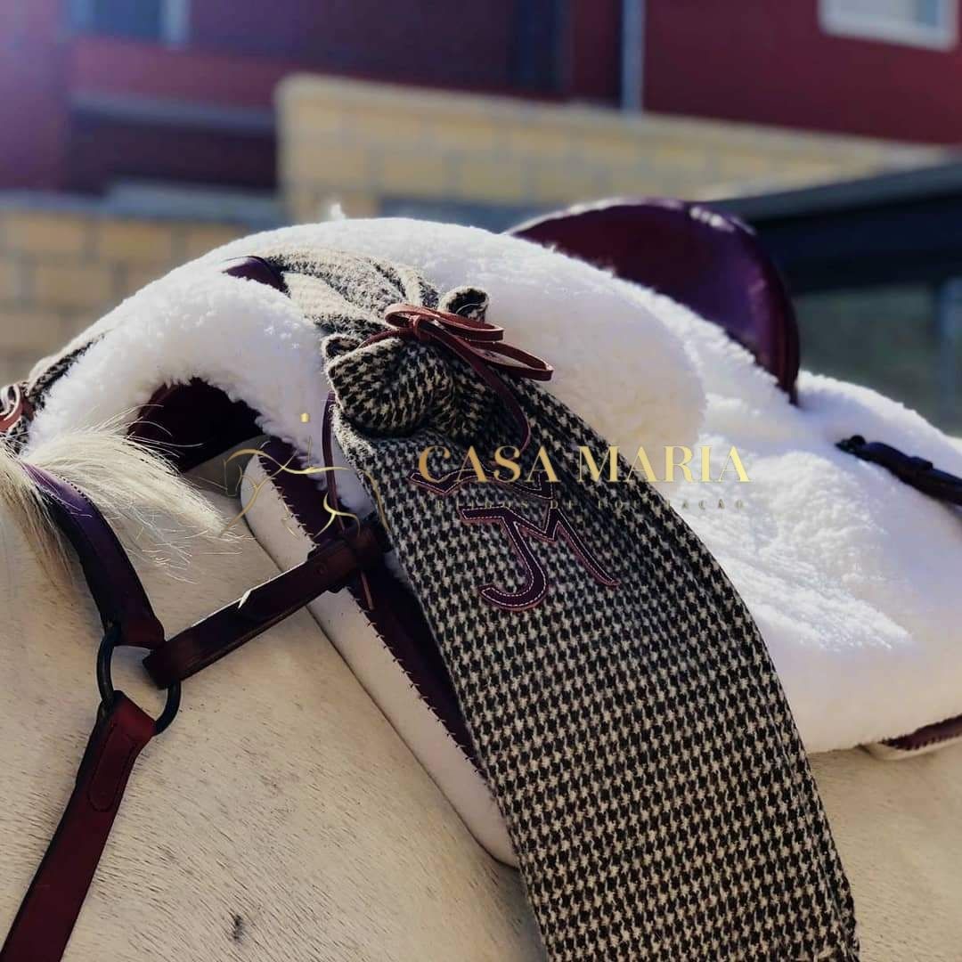 Selim de equitação castanho com almofada branca e cinta pied-de-poule com letras bordadas