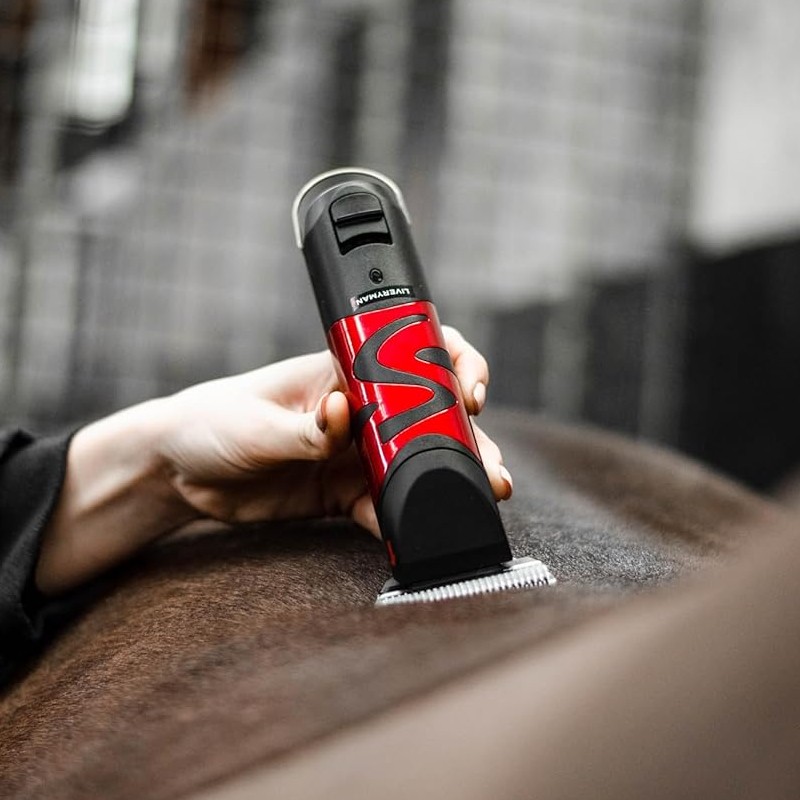 Máquina de tosquiar vermelha e preta a cortar pêlo castanho.