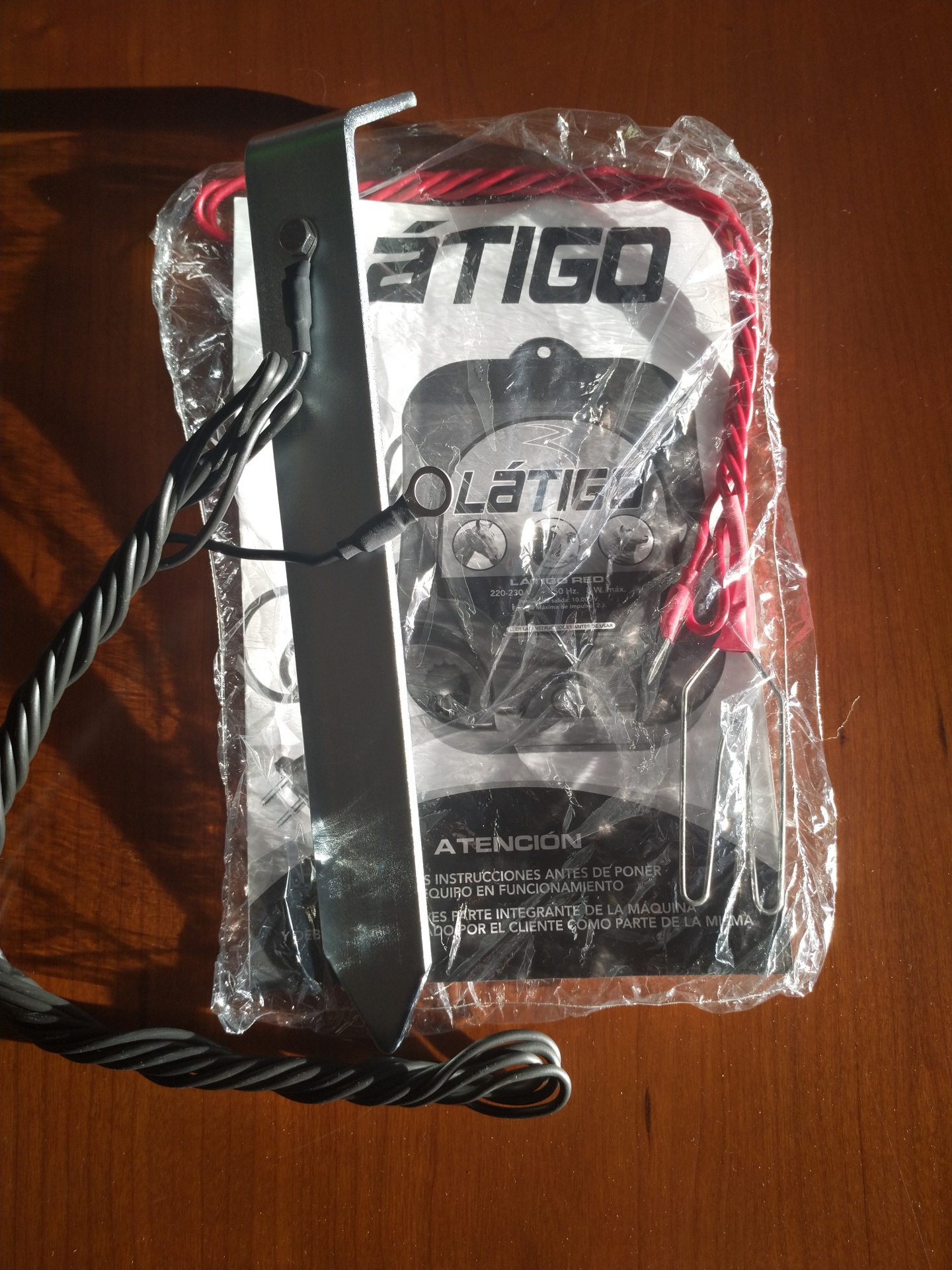 Kit de cabos elétricos com suporte metálico e embalagem plástica sobre mesa de madeira