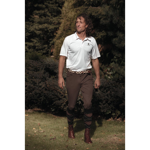 Homem com polo branco e calças marrons com padrão xadrez em ambiente exterior verde