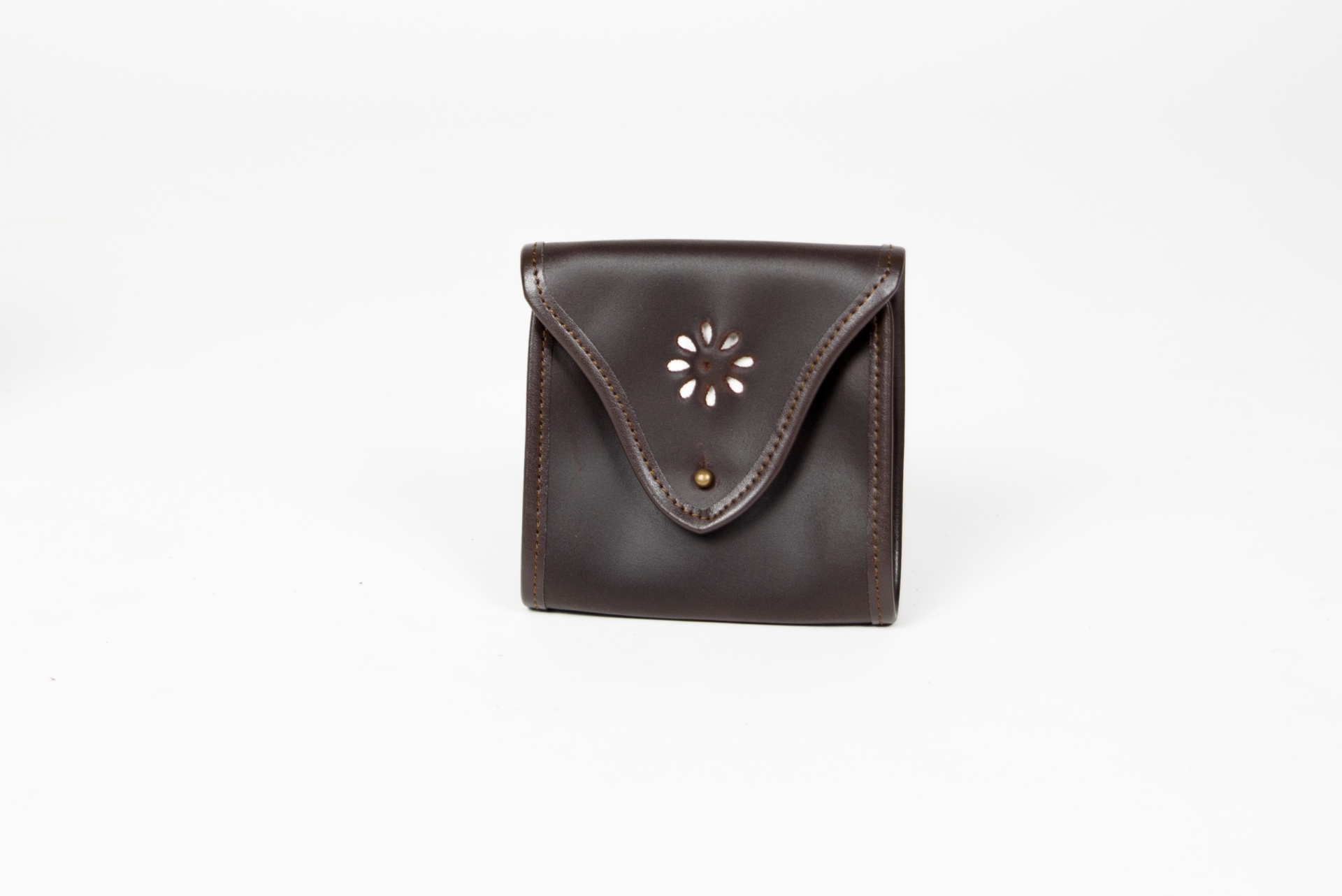 Carteira pequena de couro castanho com fecho metálico e padrão floral recortado.