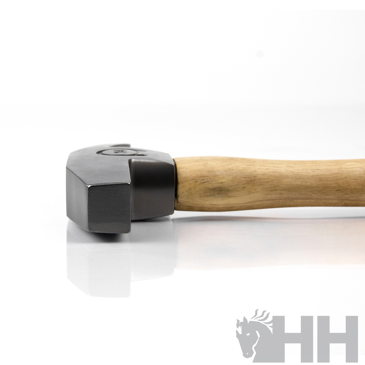 Martelo com cabeça em metal cinza escuro e cabo em madeira clara