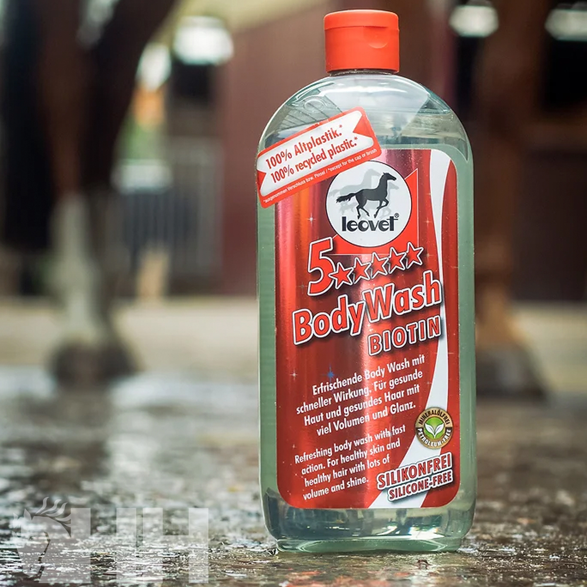 Frasco de gel de banho com rótulo vermelho em superfície molhada.