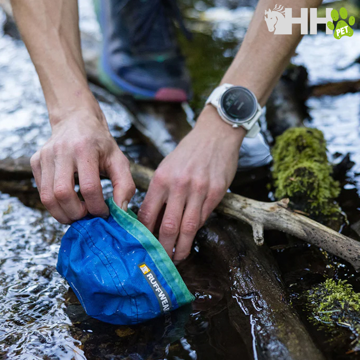 Bolsa dobrável azul com borda verde da marca RUFFWEAR num rio