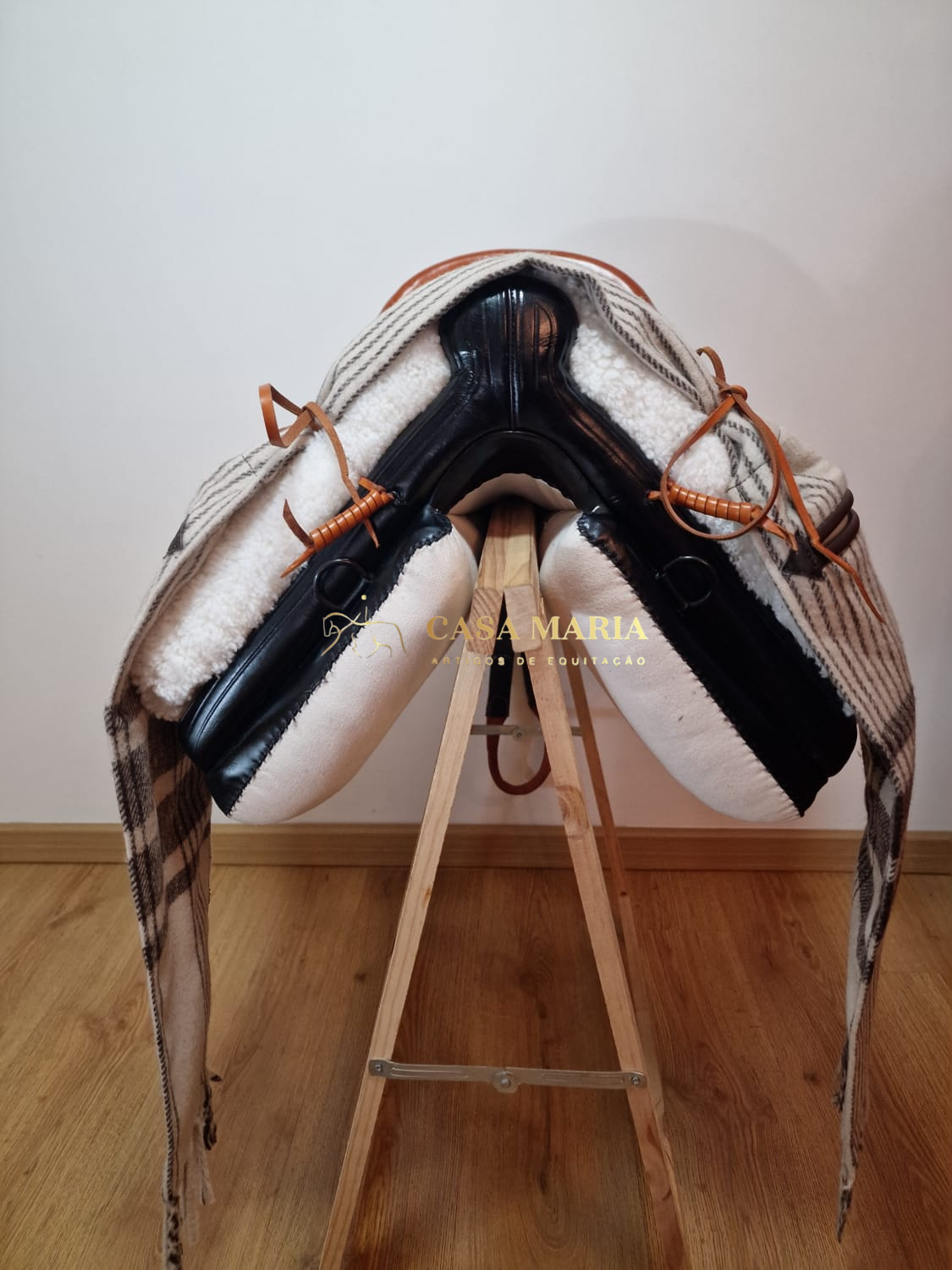 Sela de equitação em couro preto com pele branca e cinto de tiras em couro castanho