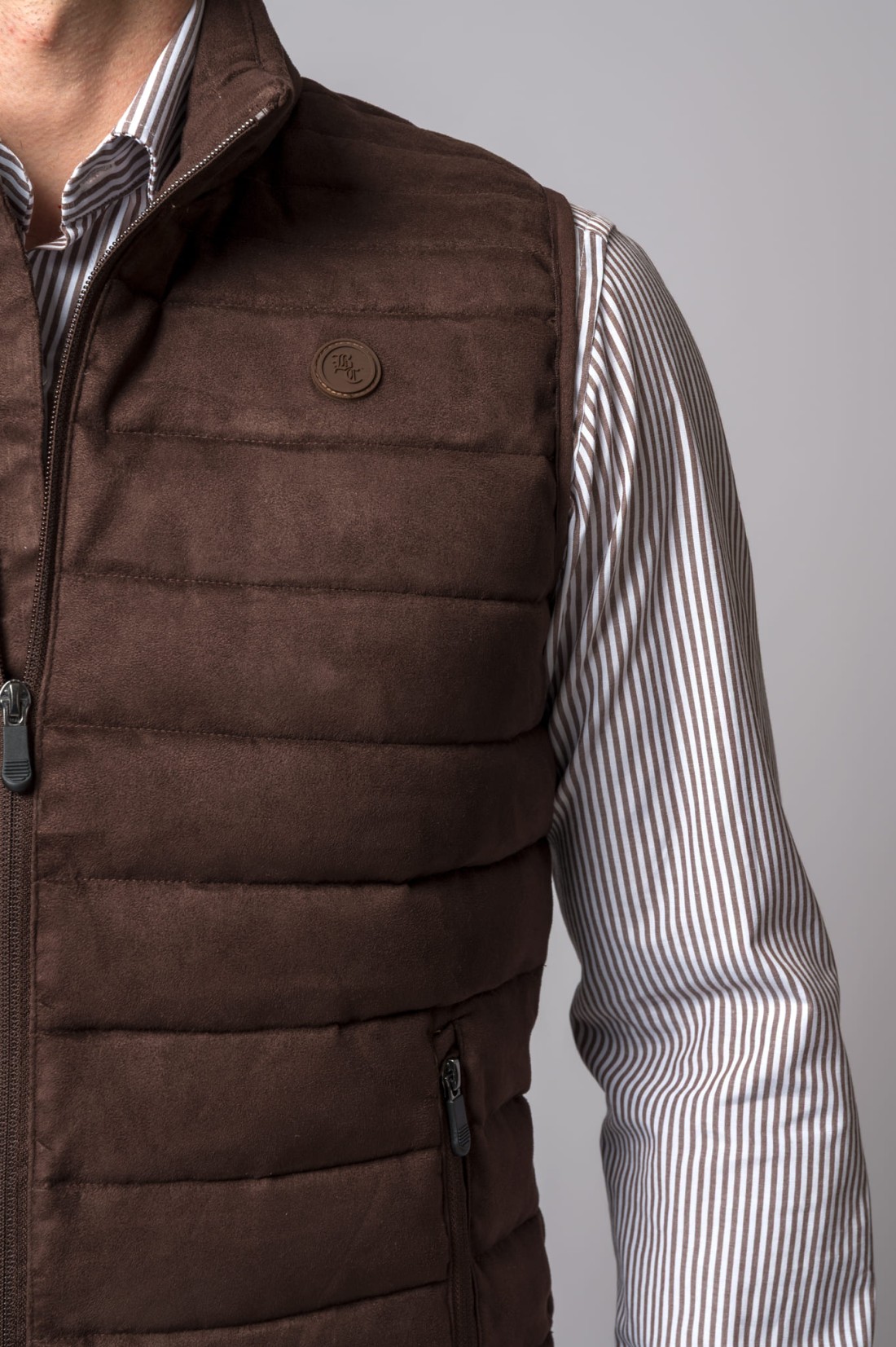 Colete castanho acolchoado com camisa riscada branca e castanha