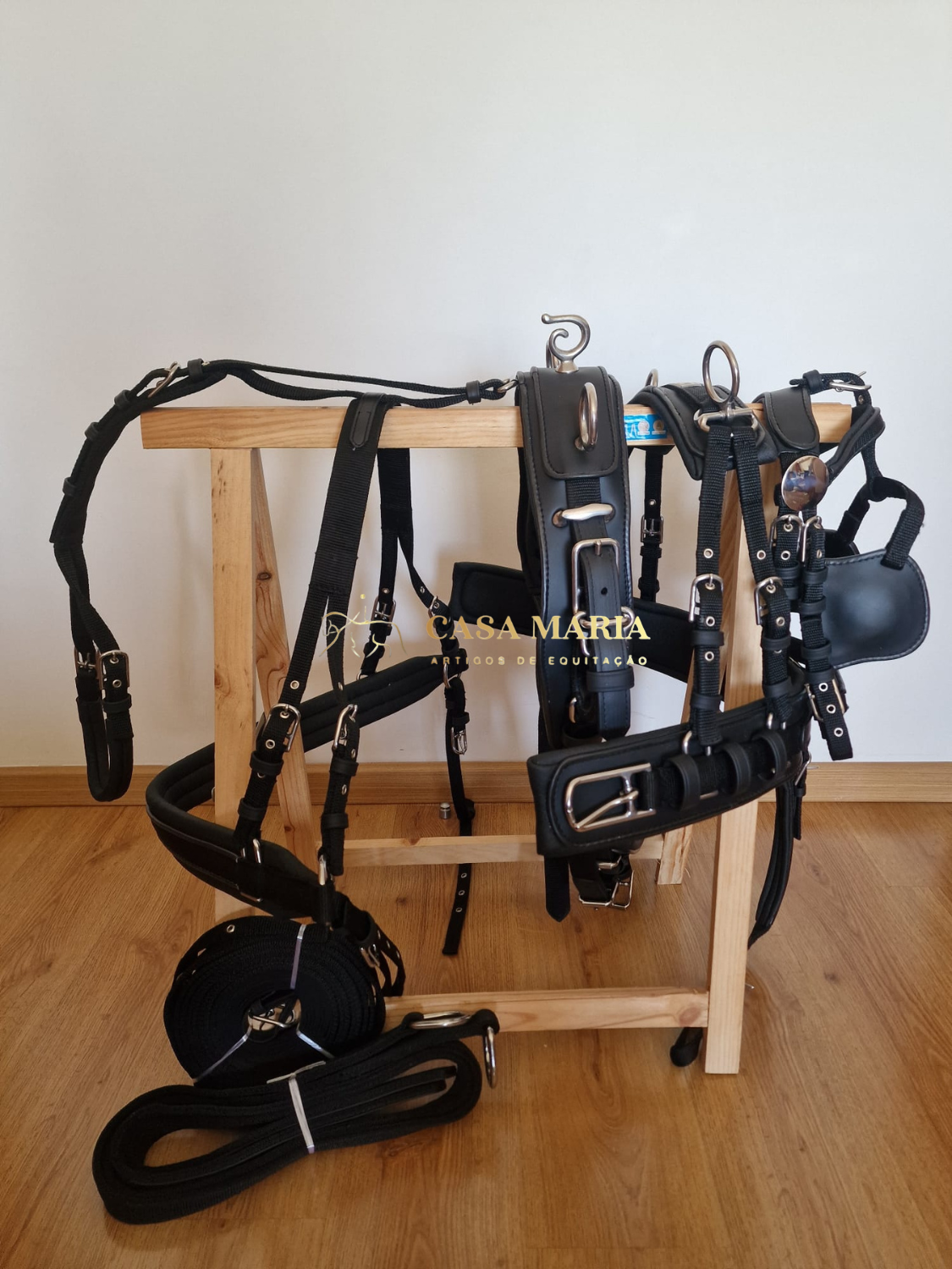 Selaria completa preta pendurada em suporte de madeira