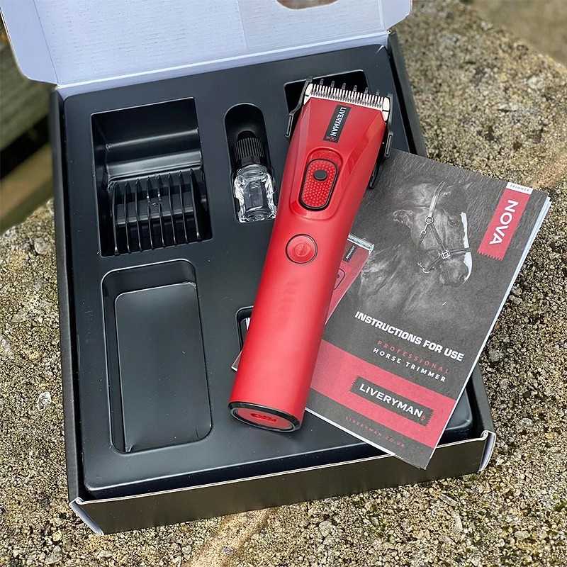 Aparelho de corte vermelho NOVA com pentes e manual na embalagem preta sobre superfície rugosa