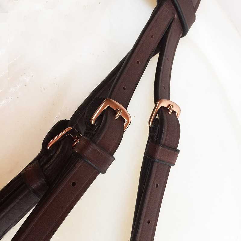 Cintos em couro castanho escuro com fivelas douradas sobre fundo branco