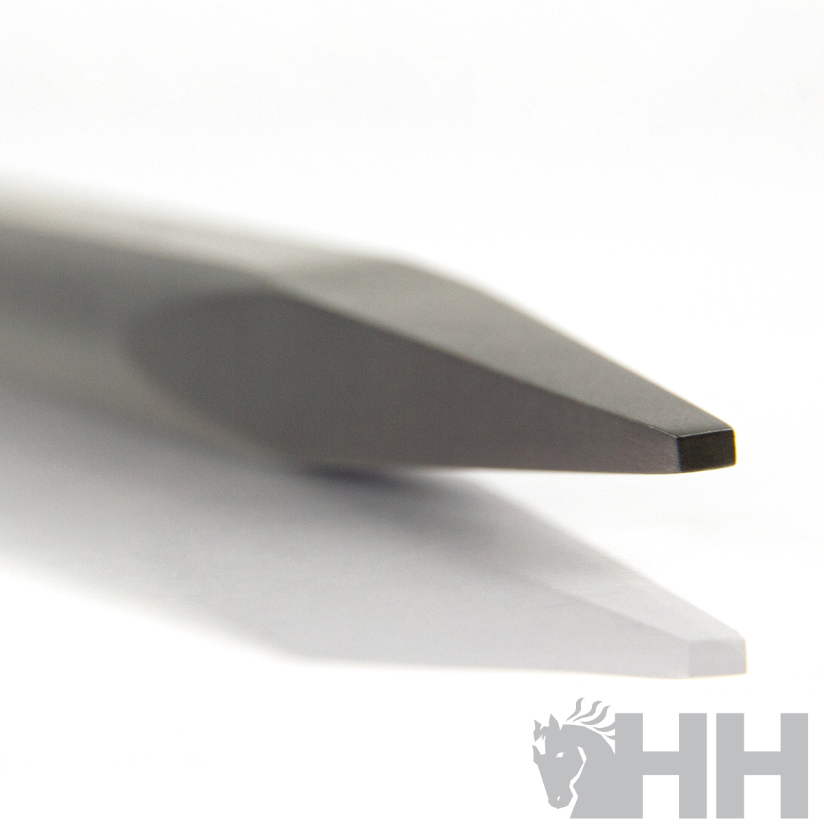 Ponta de ferramenta metálica cinza escuro com acabamento polido em fundo branco