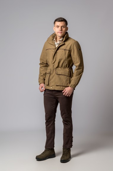 Casaco bege masculino com bolsos, capuz dobrado, calças castanhas e botas verdes, fundo cinza.